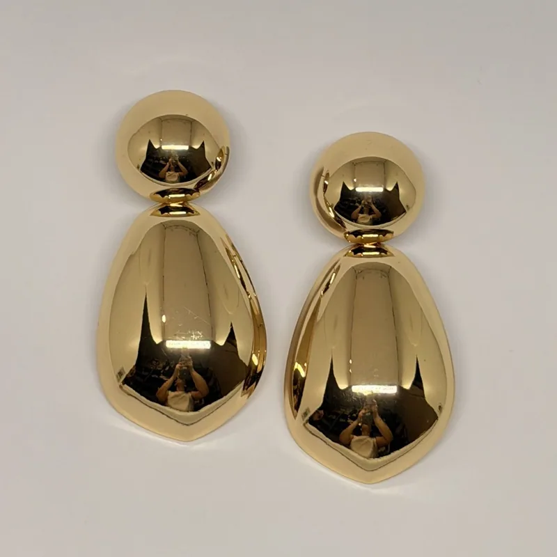 Brinco dourado pendente com esfera no topo e gota volumosa polida